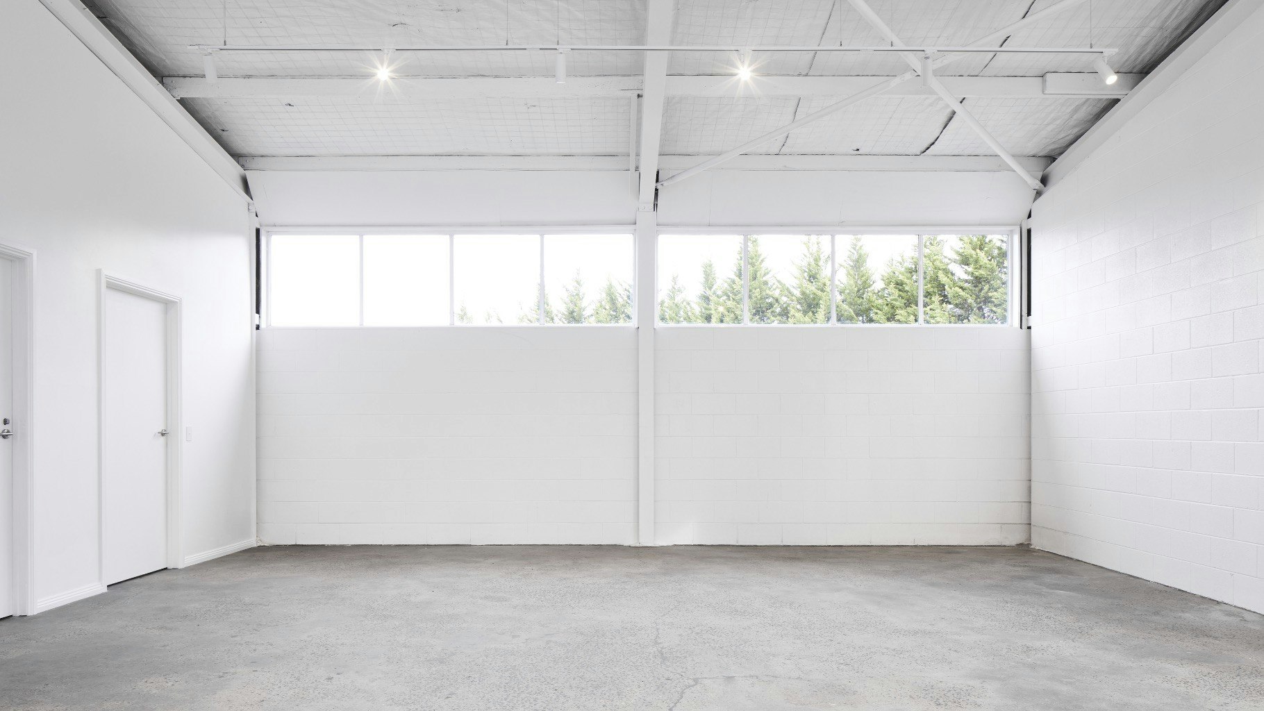 Gallery space with open windows, artwork on walls, and a fireplace centerpiece.